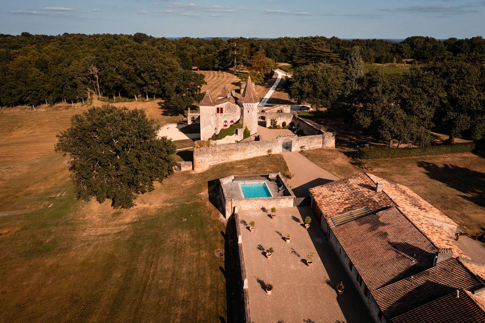 Mariage au Château Flojague proche de Saint-Emilion en Gironde, photos au drone du vin d'honneur sous les arbres.