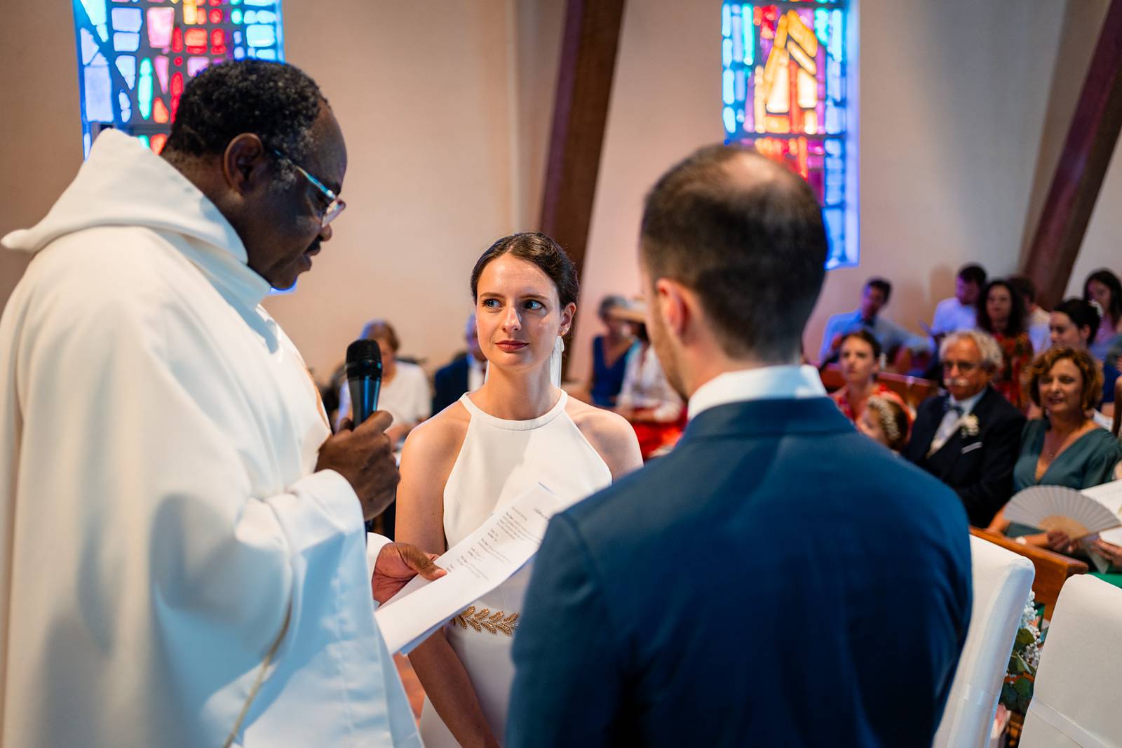 Échange des alliances dans la lumière tamisée de l’église Saint-Louis.