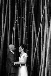 Portrait romantique des mariés entre les bambous et les arbres.