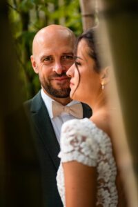 Portrait romantique des mariés entre les bambous et les arbres.