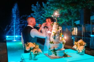 Présentation du gâteau à l’extérieur, devant le bassin illuminé.