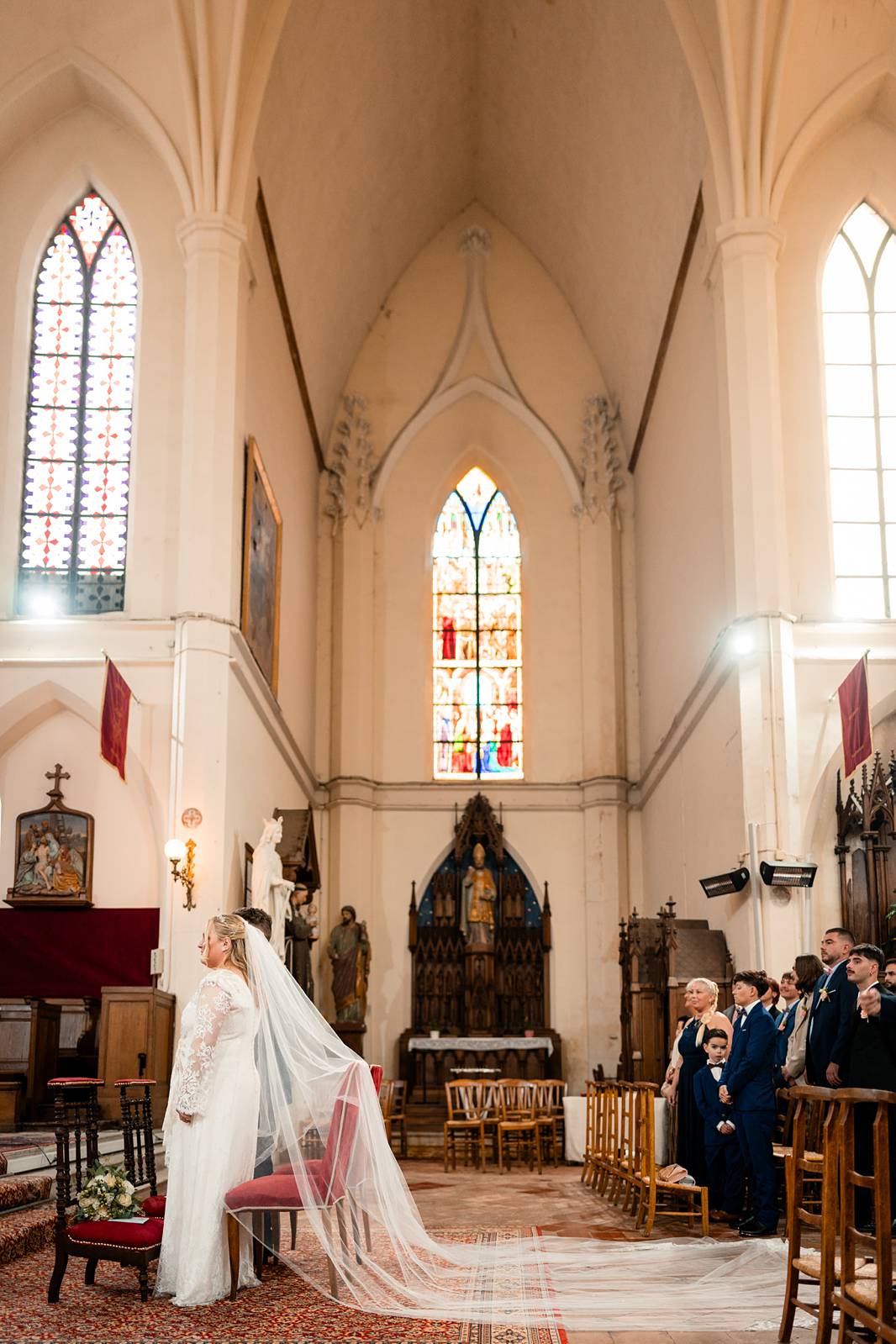 Détail du long voile en dentelle porté par la mariée à l’église