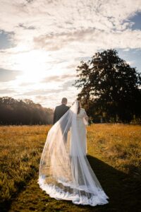 Mariés marchant main dans la main dans les jardins du château