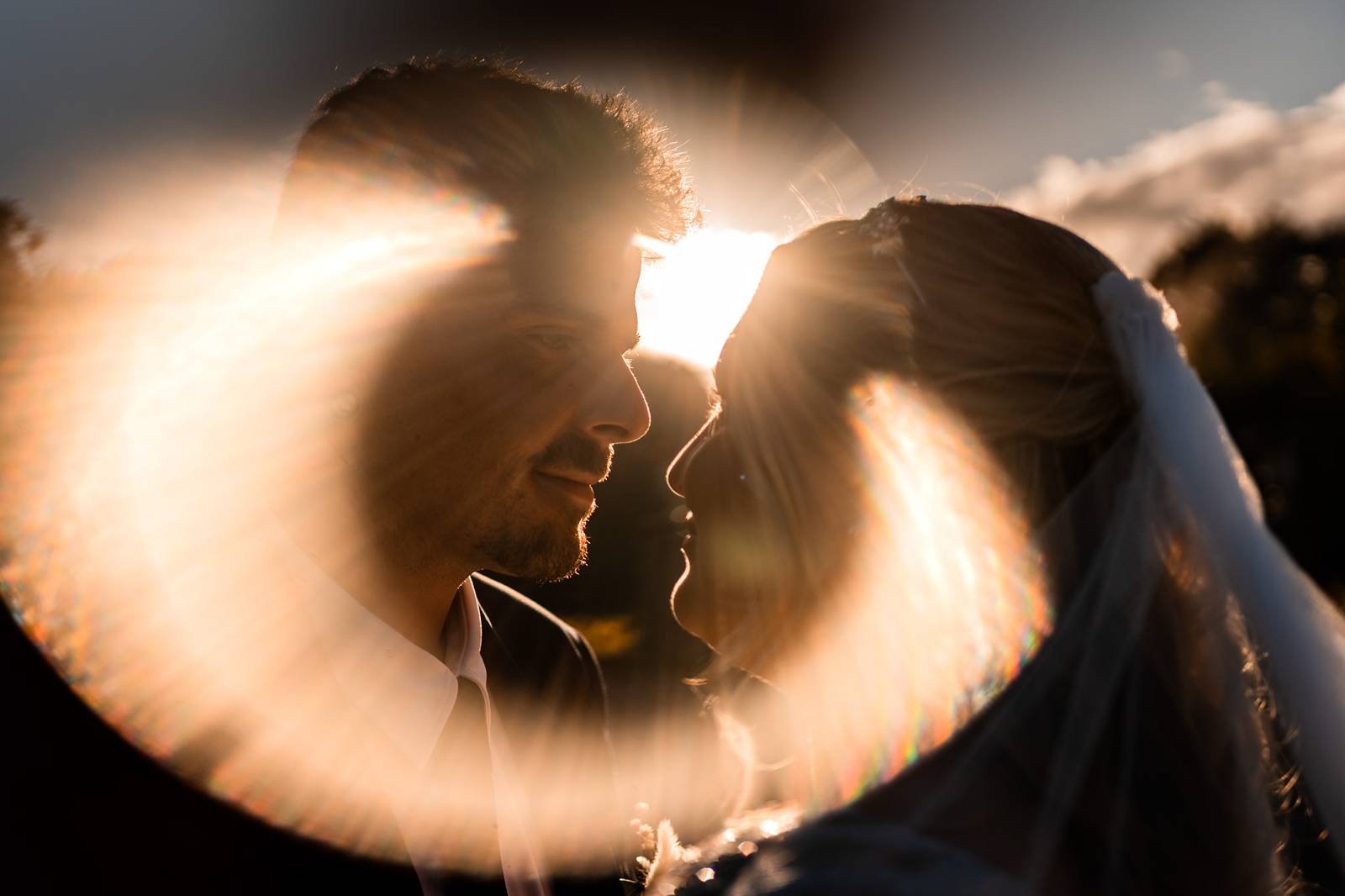 Portrait romantique des mariés au coucher du soleil près du château