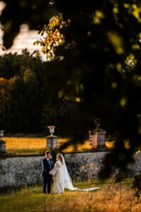 Portrait romantique des mariés au coucher du soleil près du château