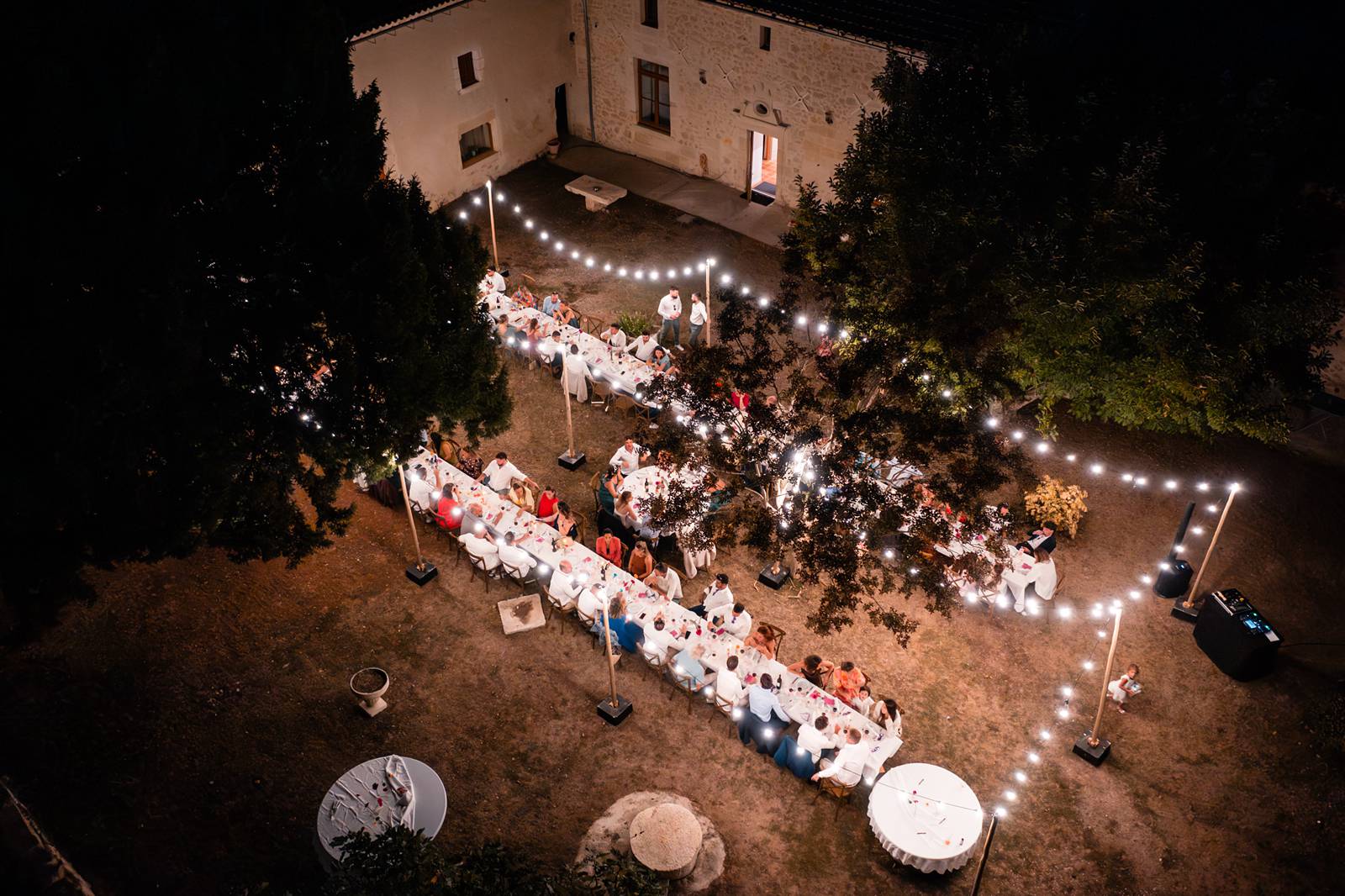 Repas de mariage en extérieur sous les guirlandes vu au Drone