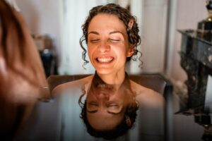 Laura se fait maquiller à la lumière naturelle dans une chambre du Château Pontet d’Eyrans