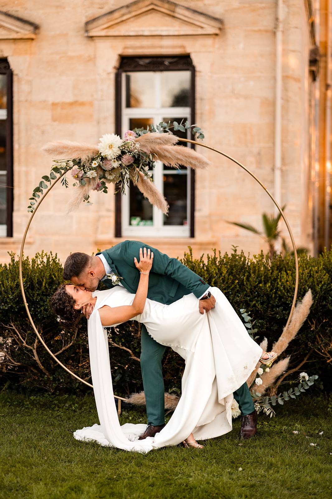 Portrait romantique des mariés au coucher du soleil devant l'arche de la cérémonie laïque