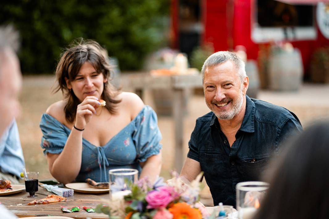 Guests enjoying a relaxed outdoor welcome dinner with wood-fired pizzas at Château de Bonnemare in Normandy.