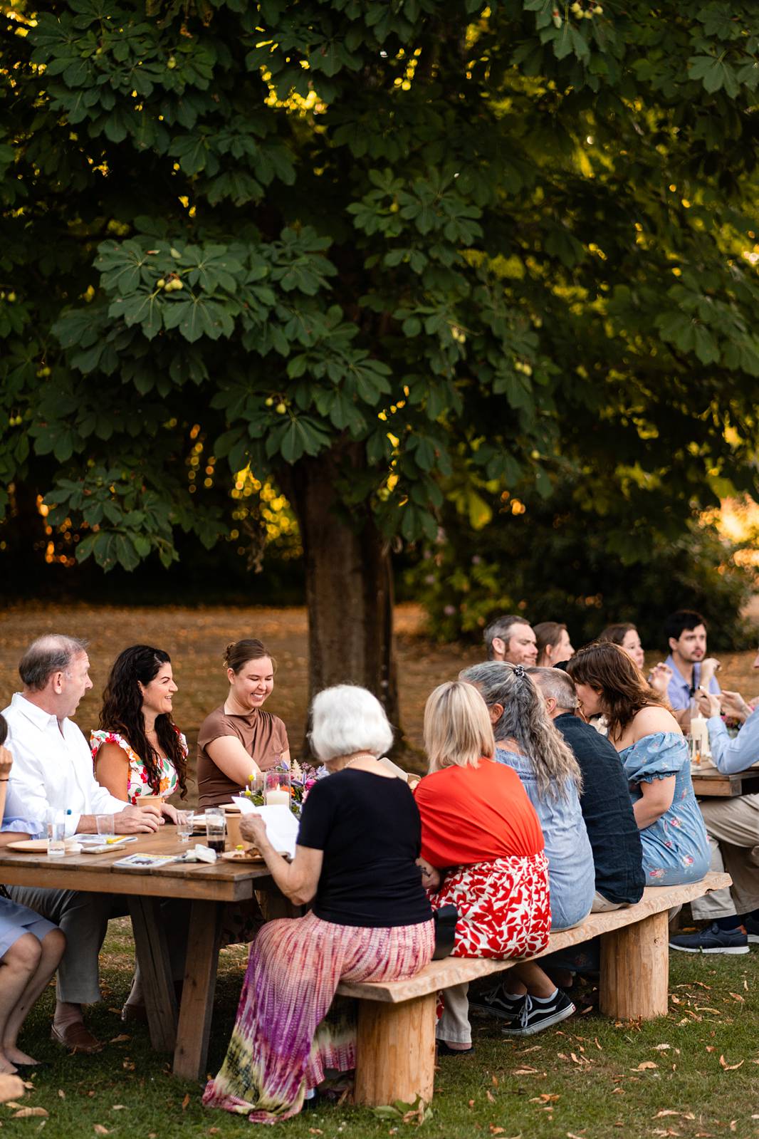 Guests enjoying a relaxed outdoor welcome dinner with wood-fired pizzas at Château de Bonnemare in Normandy.