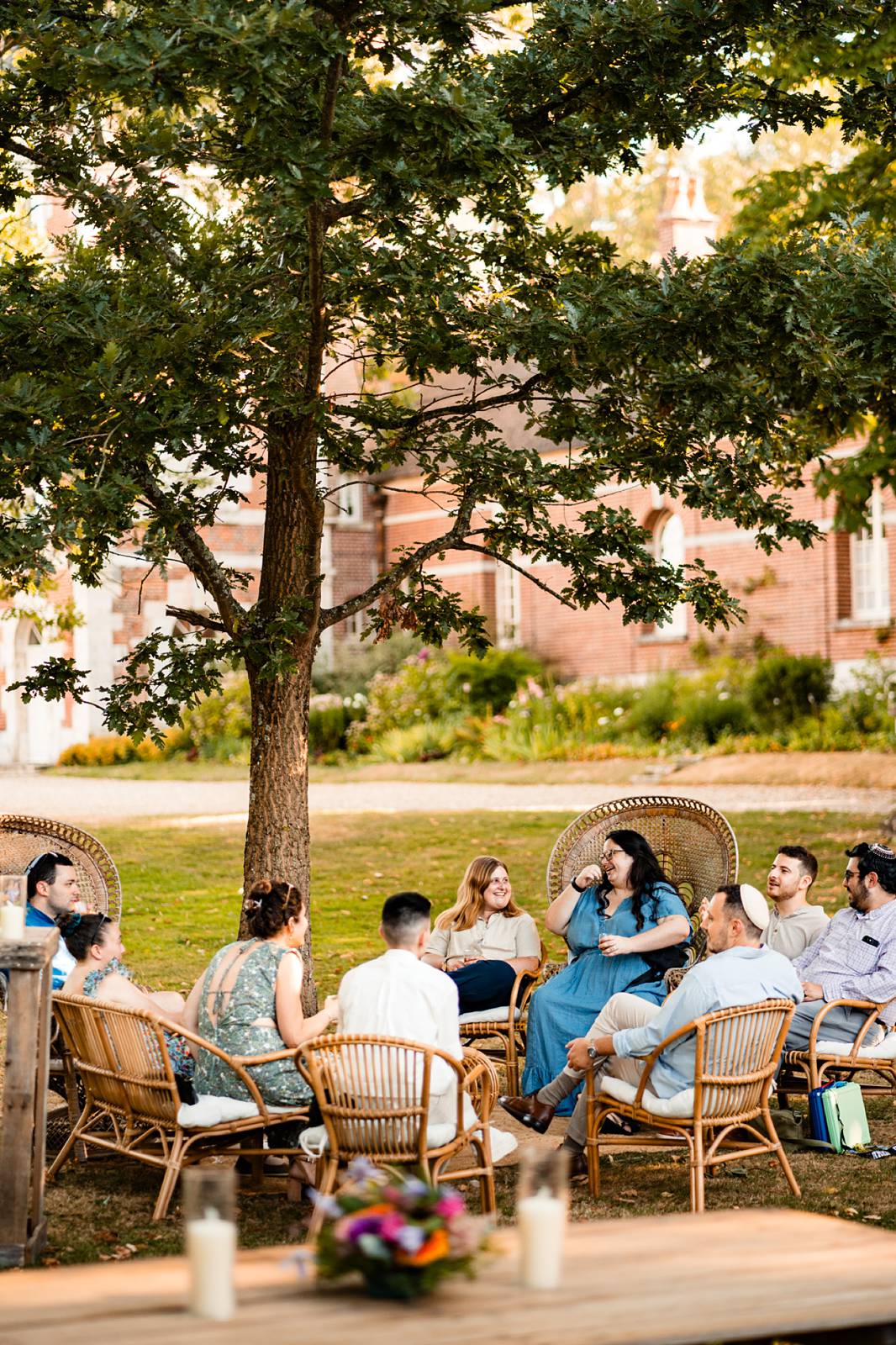 Guests enjoying a relaxed outdoor welcome dinner with wood-fired pizzas at Château de Bonnemare in Normandy.